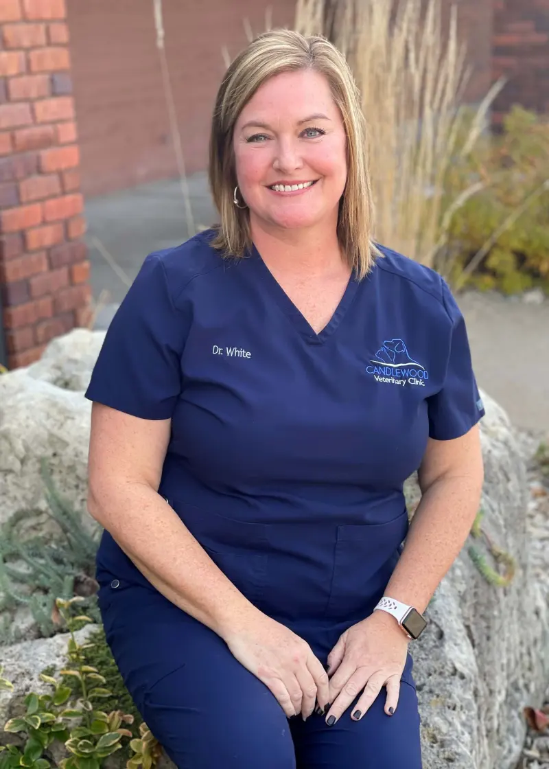 Dr. Christine White in navy scrubs, smiling outside the clinic