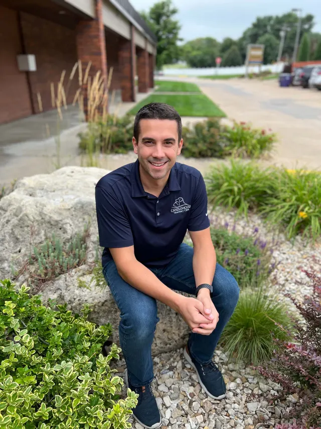 Cole, in navy Candlewood scrubs, outside the clinic
