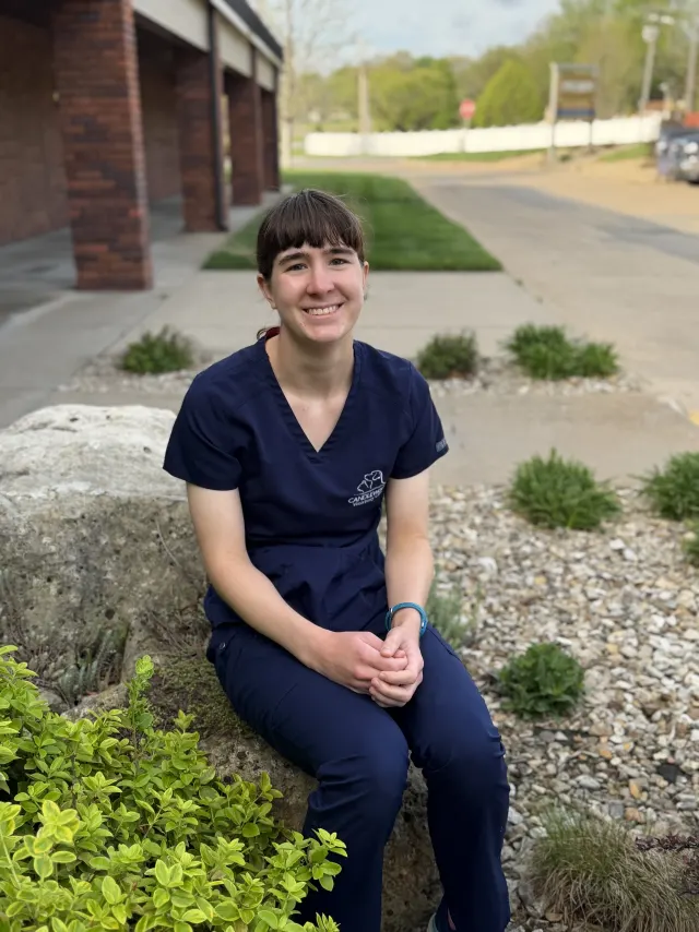 Jenny, in navy Candlewood scrubs, outside the clinic