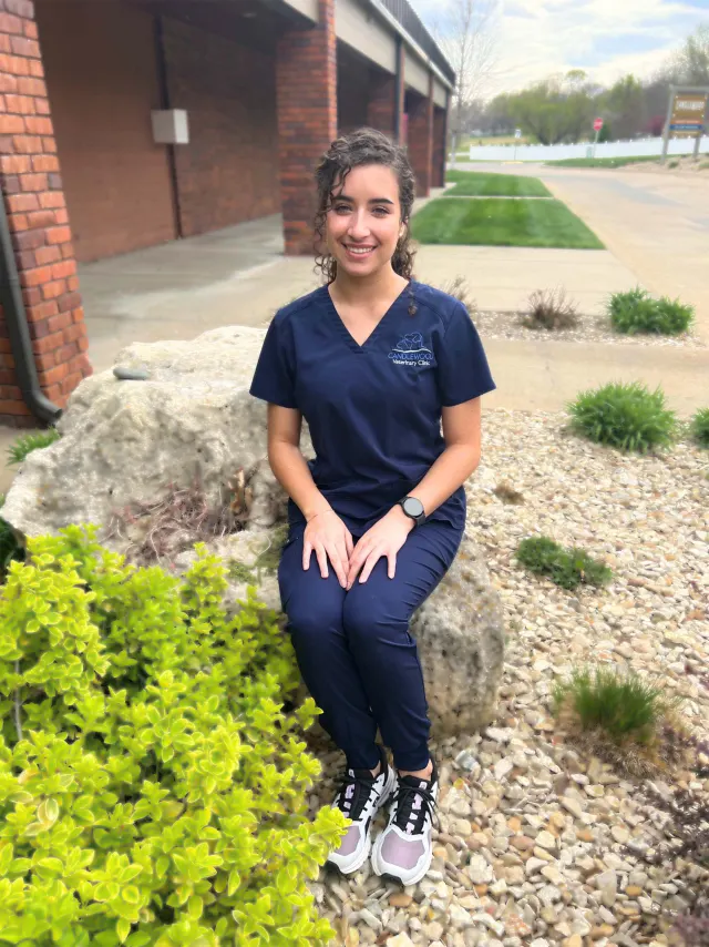 Nai, in navy Candlewood scrubs, outside the clinic